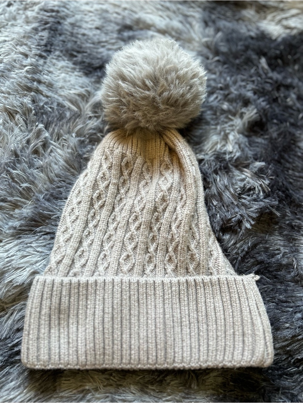 Grey twisted knit hat with cozy pompom